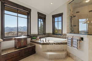 Primary Bathroom with lofted ceiling, a mountain view, a garden tub, tiled shower, and recessed lighting