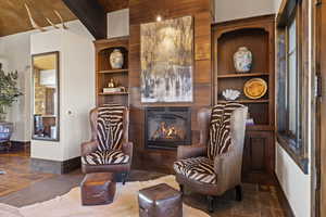 Living area featuring a glass covered fireplace and built in features
