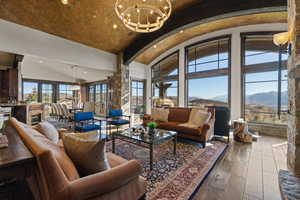 Living area featuring dark wood finished floors, a mountain view, arched walkways, hanging lights, and a high barrel ceiling