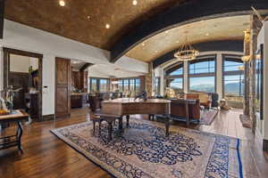 Dining area with dark wood-style floors, a barrel ceiling, a mountain view, and hanging lights