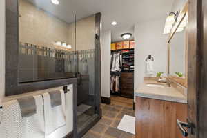 Tree bedroom bathroom featuring vanity, recessed lighting, a shower stall, a spacious closet, and dark tile patterned flooring
