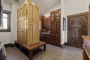Mudroom with baseboards and lofted ceiling