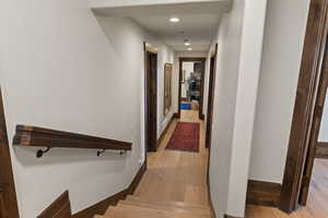 Hall leading to King & Queen guest suites with light wood-style floors and recessed lighting