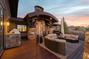 Deck at dusk with an outdoor kitchen and area to lounge