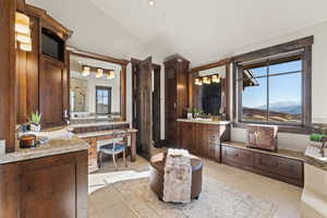 Primary  Bathroom featuring lofted ceiling, two vanities, a mountain view, walk in shower, and recessed lighting