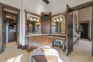 Primary  Bathroom with a spacious closet, vanity, washer / clothes dryer, and light tile patterned floors