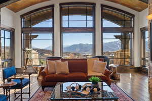 Living room with dark wood-style floors, a mountain view, healthy amount of natural light, and vaulted ceiling
