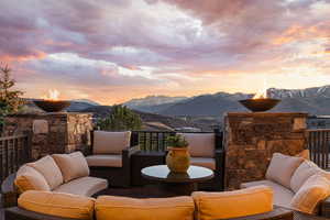 Deck at dusk with an outdoor living space with a fire pit, a mountain view, and a patio area