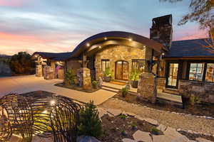View of front of house featuring stone siding, driveway, and an attached garage