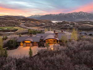 View of front of property featuring stone siding, a chimney, a mountain view, and concrete driveway