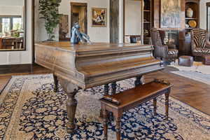 Misc room with dark wood-style floors and a glass covered fireplace