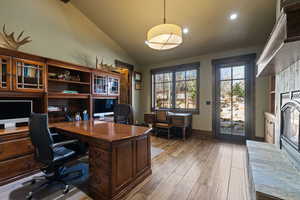 Main level Bedroom/Used as Office with light wood-type flooring and vaulted ceiling large closet closet.