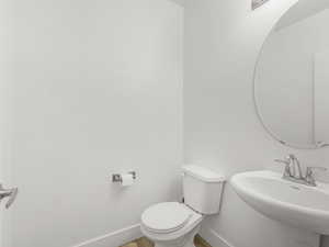 Bathroom with toilet and wood finished floors