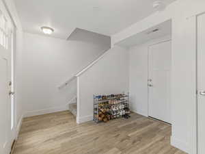 Foyer with light wood-style floors and stairway