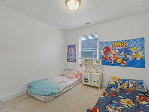 Bedroom with light colored carpet and baseboards