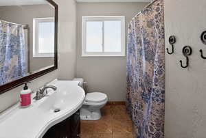 Full bath with vanity, a shower with curtain, tile patterned flooring, and a textured wall