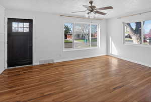 Entrance foyer with wood finished floors, a ceiling fan, and a textured ceiling