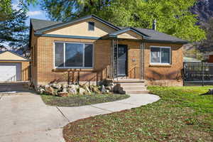 Bungalow-style house with an outdoor structure, a garage, and brick siding