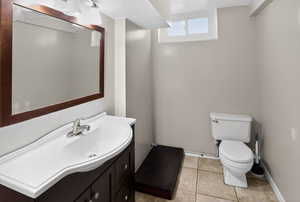 Half bath featuring vanity, light tile patterned flooring, and a textured ceiling