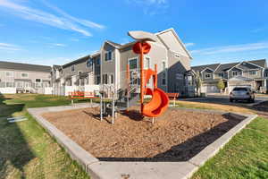 Community play area with a residential view and a lawn