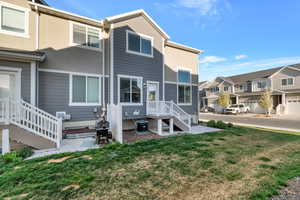 Rear view of property featuring a yard, a residential view, stucco siding, and a patio area
