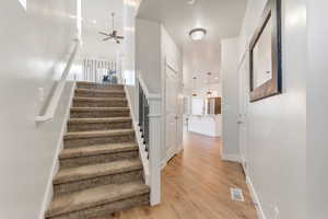 Stairs with wood finished floors, ceiling fan, and recessed lighting