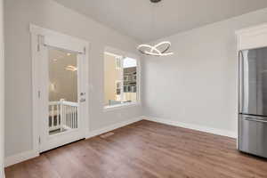 Unfurnished dining area with light wood finished floors and suspended lighting