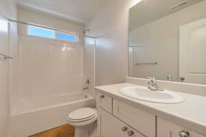 Bathroom featuring vanity, tub / shower combination, and light tile patterned flooring