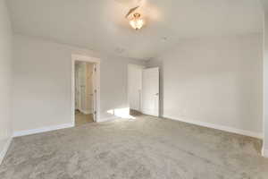 Unfurnished bedroom featuring light carpet and vaulted ceiling
