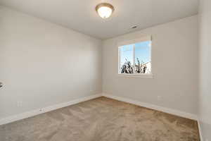 Unfurnished room with baseboards and light colored carpet