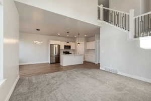 Unfurnished living room with dark carpet and recessed lighting