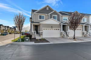 Craftsman-style home featuring a residential view, concrete driveway, stone siding, board and batten siding, and stucco siding