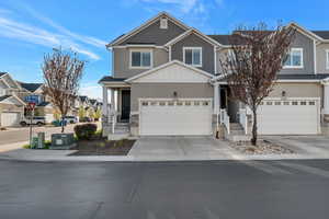 Craftsman inspired home featuring board and batten siding, a residential view, driveway, a garage, and stucco siding