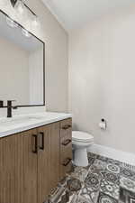 Half bathroom featuring vanity and light tile patterned flooring
