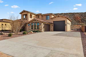 Mediterranean / spanish house with a garage, driveway, stucco siding, and a tiled roof