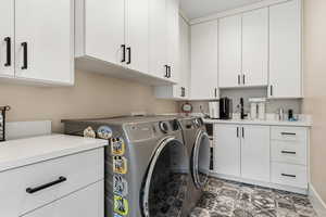 Laundry area with cabinet space and washing machine and clothes dryer