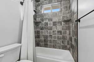 Bathroom featuring toilet and shower / bath combo