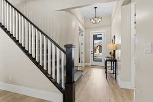 Entrance foyer featuring light wood finished floors and a chandelier