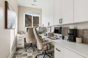 Office featuring built in desk and baseboards