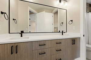 Full bath featuring double vanity and curtained shower