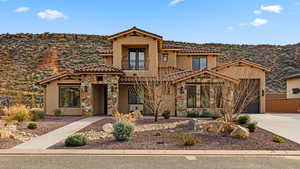 Mediterranean / spanish house with a balcony, driveway, a mountain view, a tiled roof, and stone siding