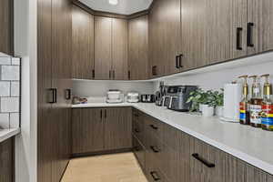 Kitchen with light wood-type flooring, modern cabinets, and dark wood finish cabinets