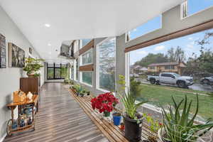 Corridor featuring plenty of natural light, wood finished floors, and recessed lighting