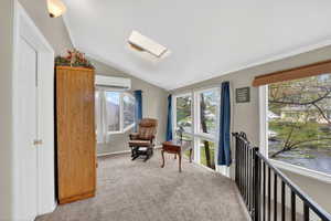 Sitting room featuring vaulted ceiling, a skylight, and carpet