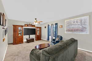 Living room with carpet flooring and ceiling fan