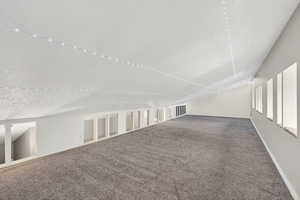 Bonus room with carpet flooring and a textured ceiling