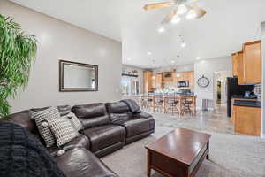 Living room with arched walkways, a ceiling fan, recessed lighting, and light colored carpet