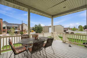 Covered deck featuring a view of the fenced horse pasture with outdoor dining space