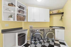Laundry room featuring cabinet space and independent washer and dryer