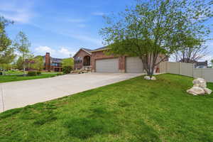 View of front of property featuring brick siding, an attached garage, driveway